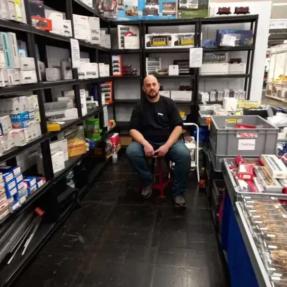 Modelleisenbahnanlage mit mehreren Zügen auf verschiedenen Gleisen.