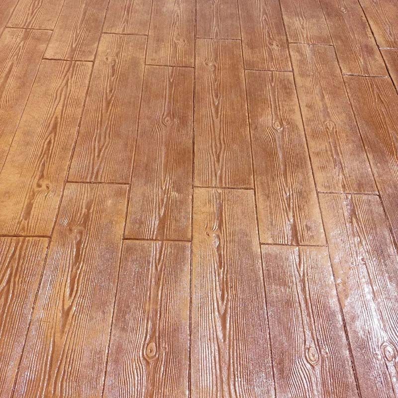 Piso de hormigón estampado de color marrón que imita un patrón de tablones de madera.