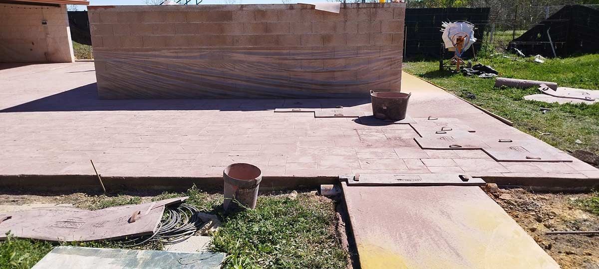 Una obra en construcción con una gran estructura de ladrillos y un pájaro en el césped.