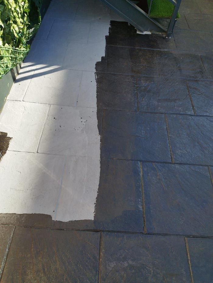 La mitad de un patio de piedra es oscura, tratada; la otra mitad es clara, sin tratar.