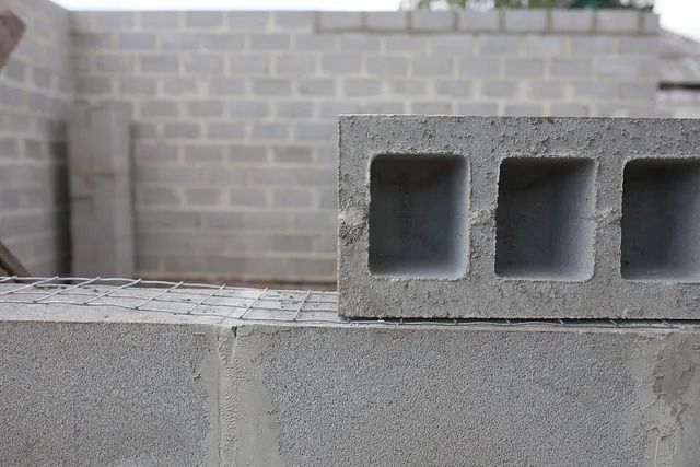 Una pila de bloques de hormigón colocados uno encima del otro frente a una pared de ladrillos.