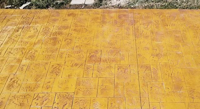 Un primer plano de un piso de concreto amarillo con un patrón en él.