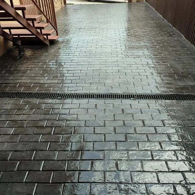 Una pasarela de ladrillo con escaleras y un desagüe.