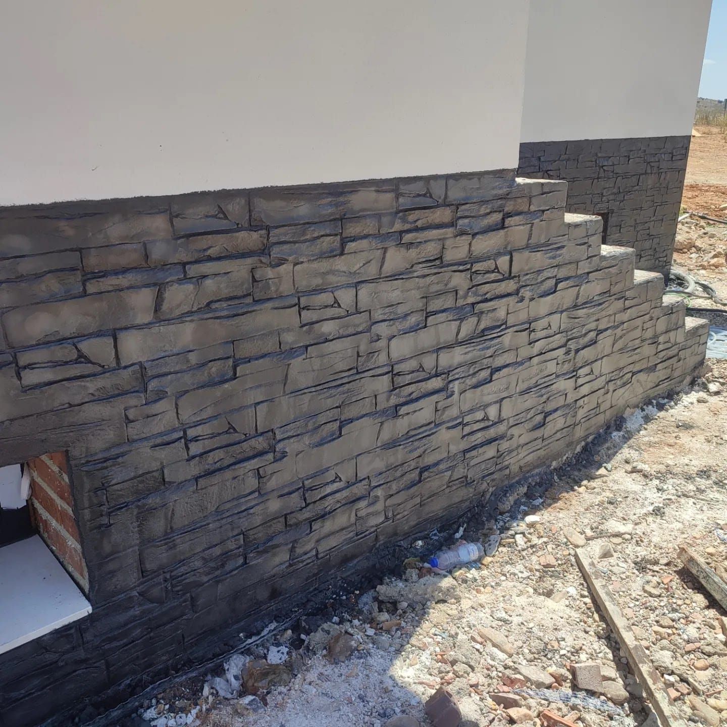 Se está construyendo un muro de ladrillos en el costado de un edificio.