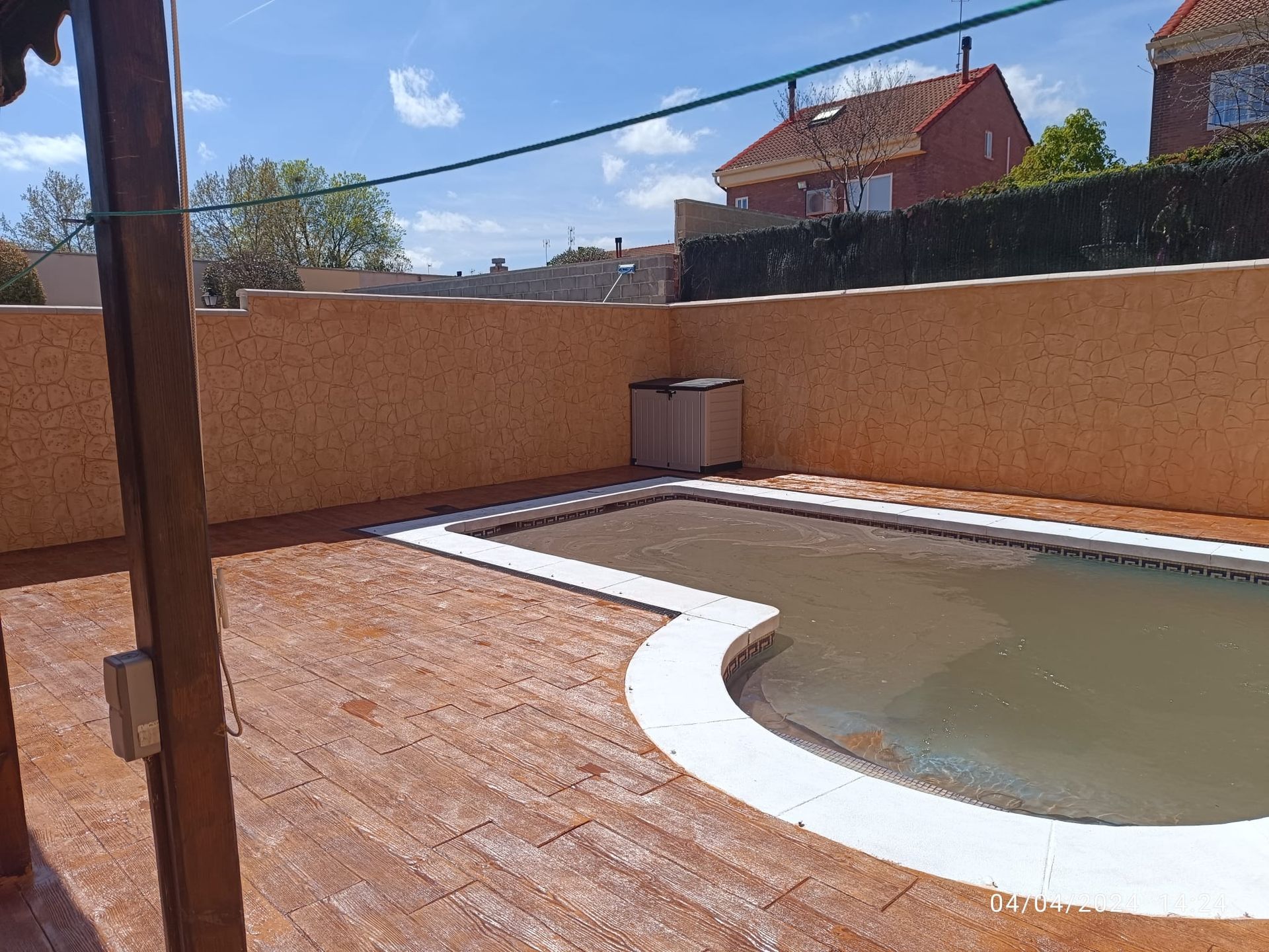 Una gran piscina está rodeada por una pared de ladrillos.