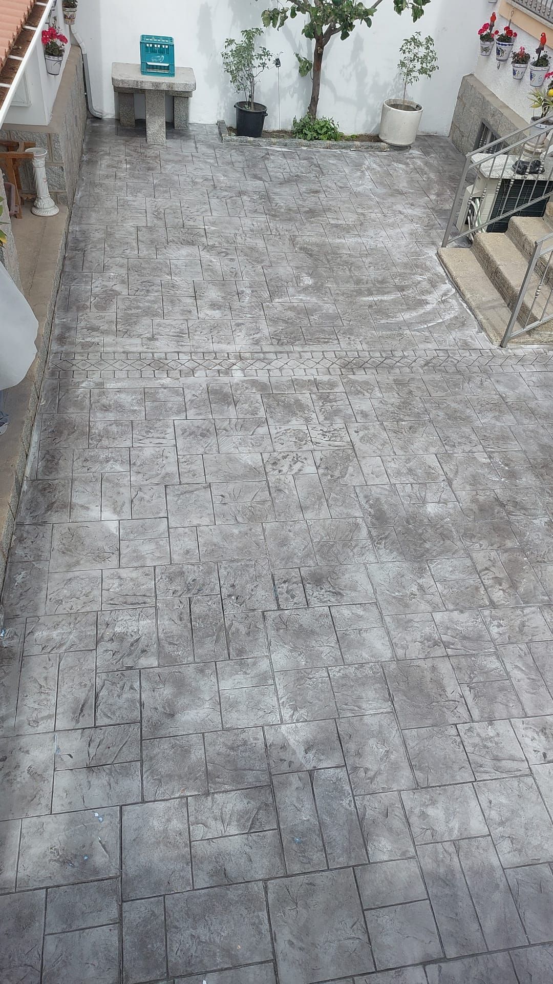 Un patio con piso de concreto y escaleras que conducen al mismo.