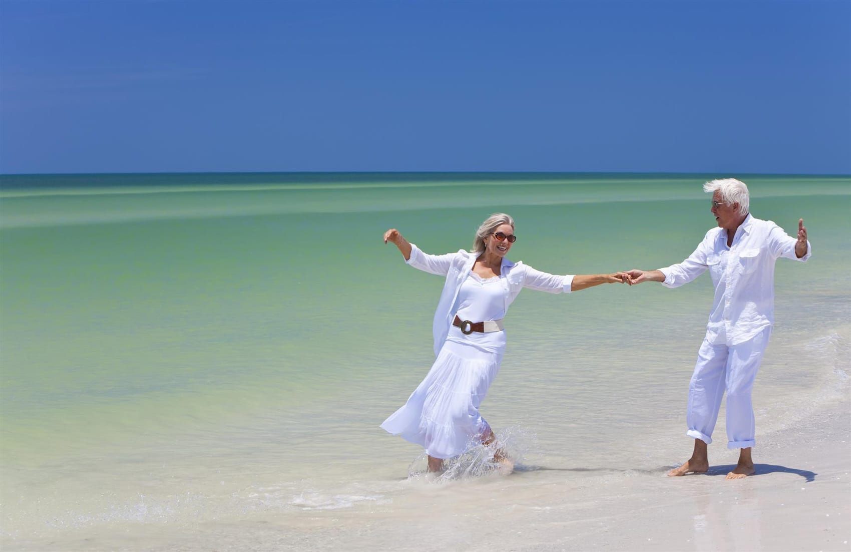 Seniorenpaar in weißer Sommerkleidung am Strand, Ingrid Mack partner for you