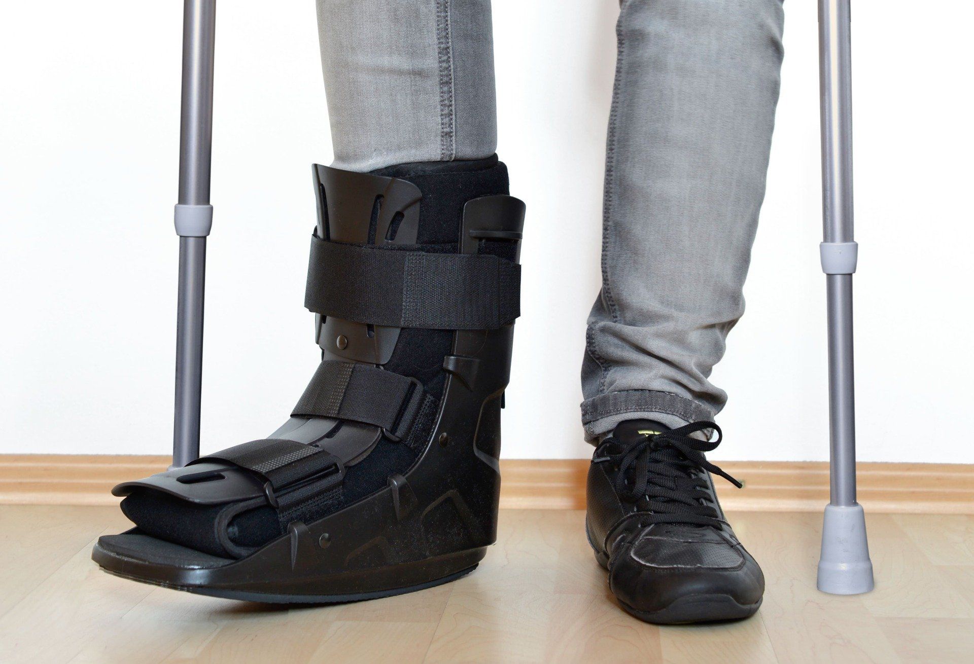 Patient portant une orthèse du pied avec des béquilles