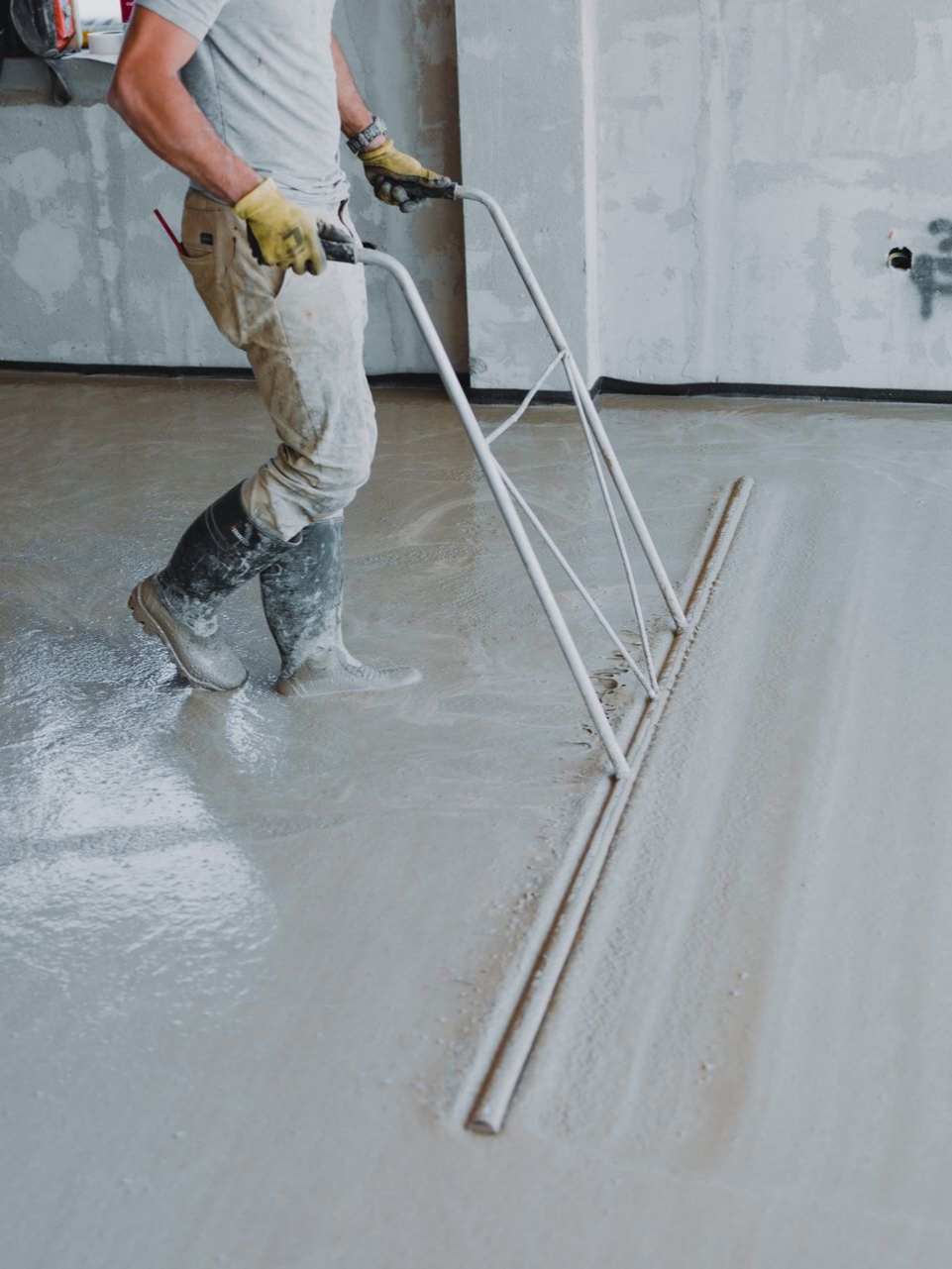 Un homme lissant du béton liquide