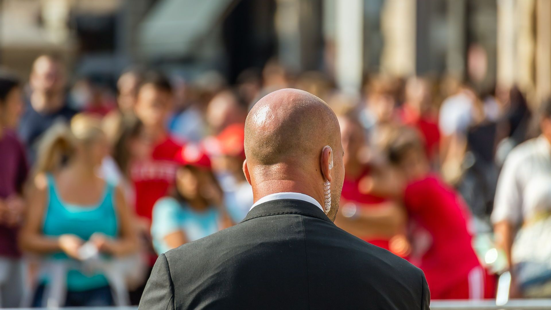 Agent de sécurité de dos devant une foule
