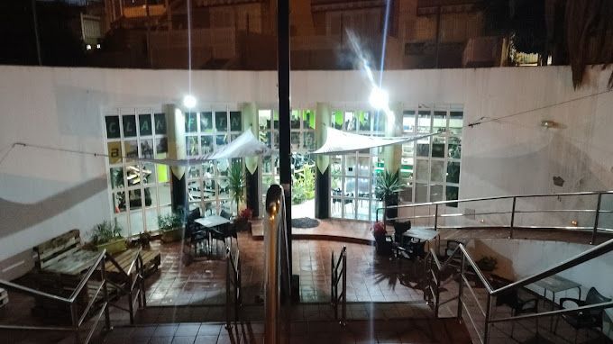 Una vista de un edificio de noche con mesas y sillas.