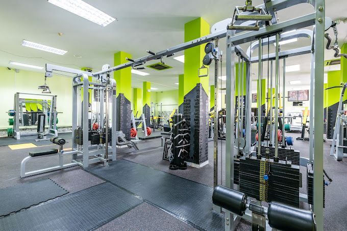 Un gran gimnasio lleno de muchos equipos de ejercicio.