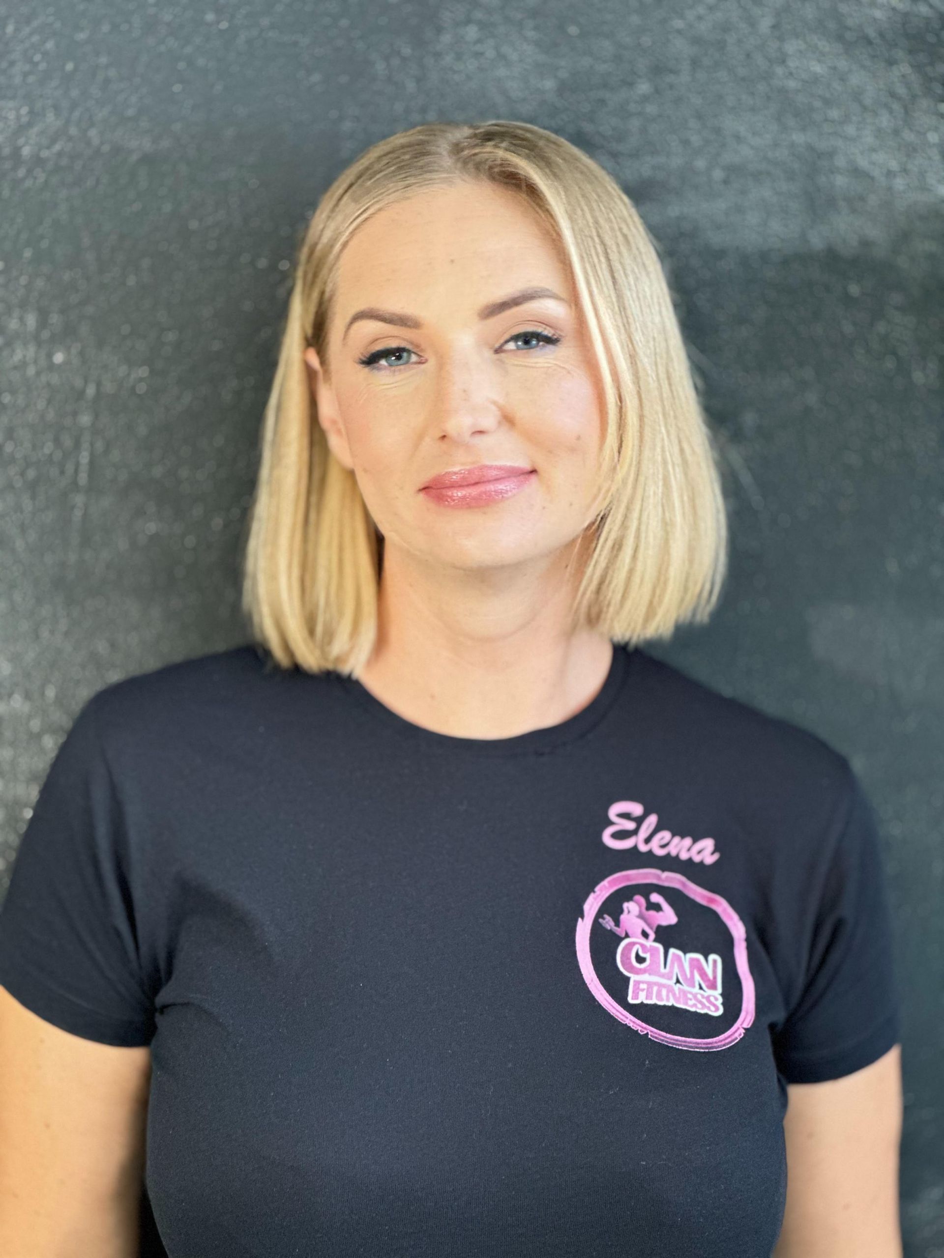 Una mujer que lleva una camisa negra con el nombre Elena escrito en ella.