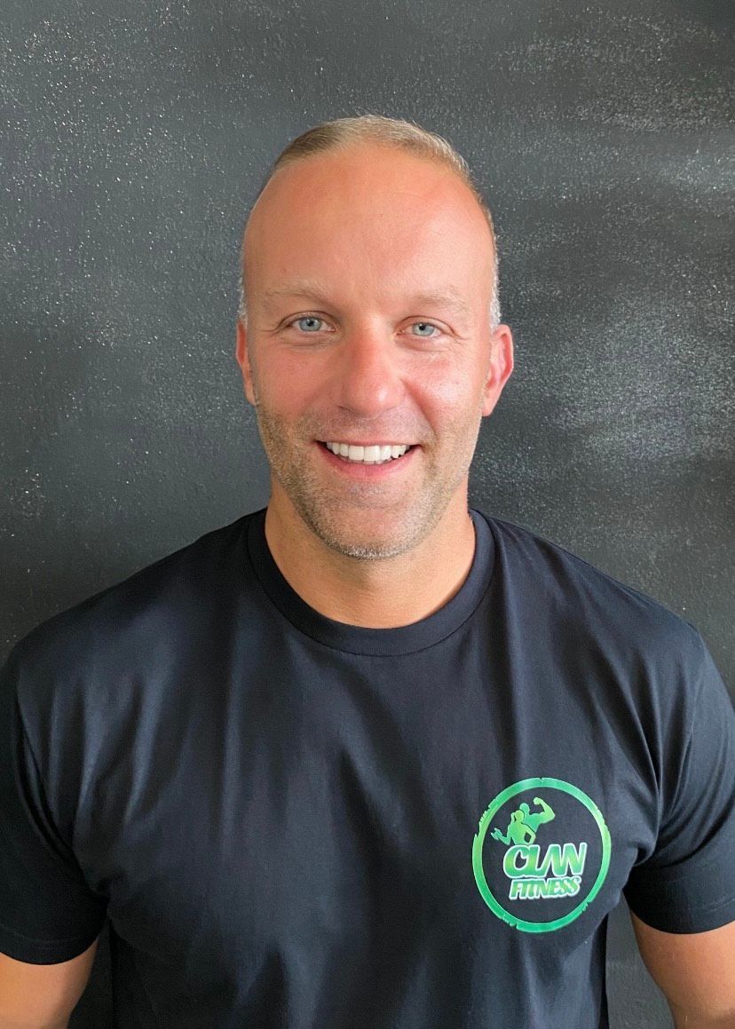 Un hombre que lleva una camisa negra con un logo verde.