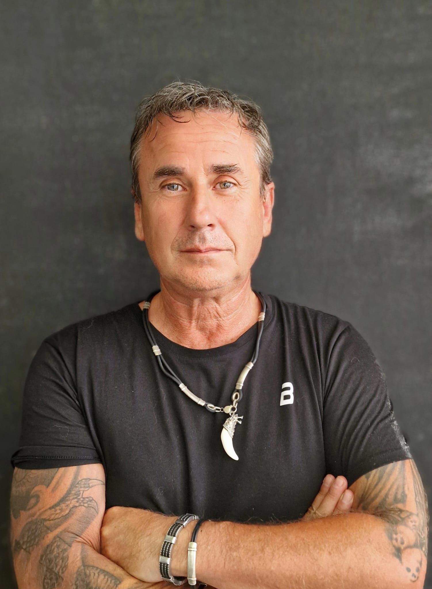 Un hombre que lleva una camisa negra con la letra a en ella.