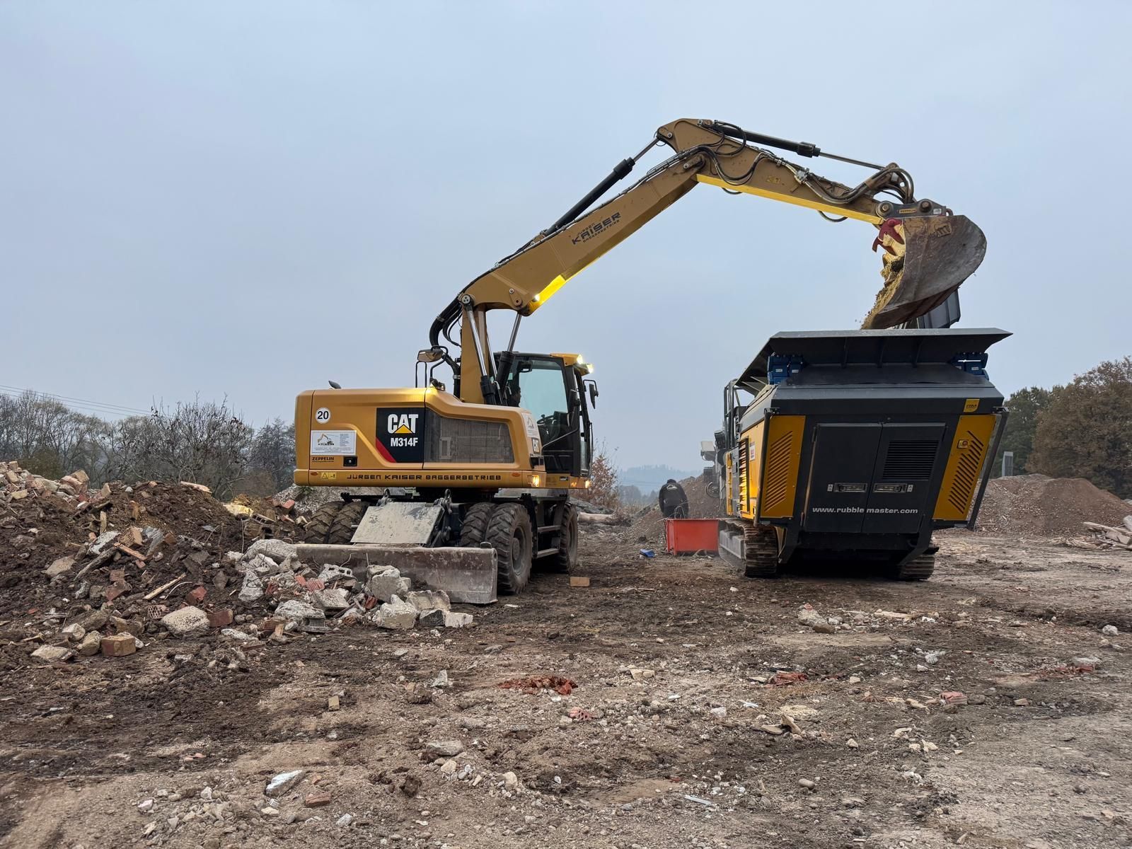 Abrissbagger reißt Gebäude ein – Gelber Bagger im Einsatz bei Abbrucharbeiten, Staub und Trümmer fliegen.