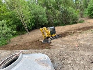 Bagger hebt Graben aus – Bauarbeiten auf einer Baustelle für Versorgungsleitungen oder Fundamente.