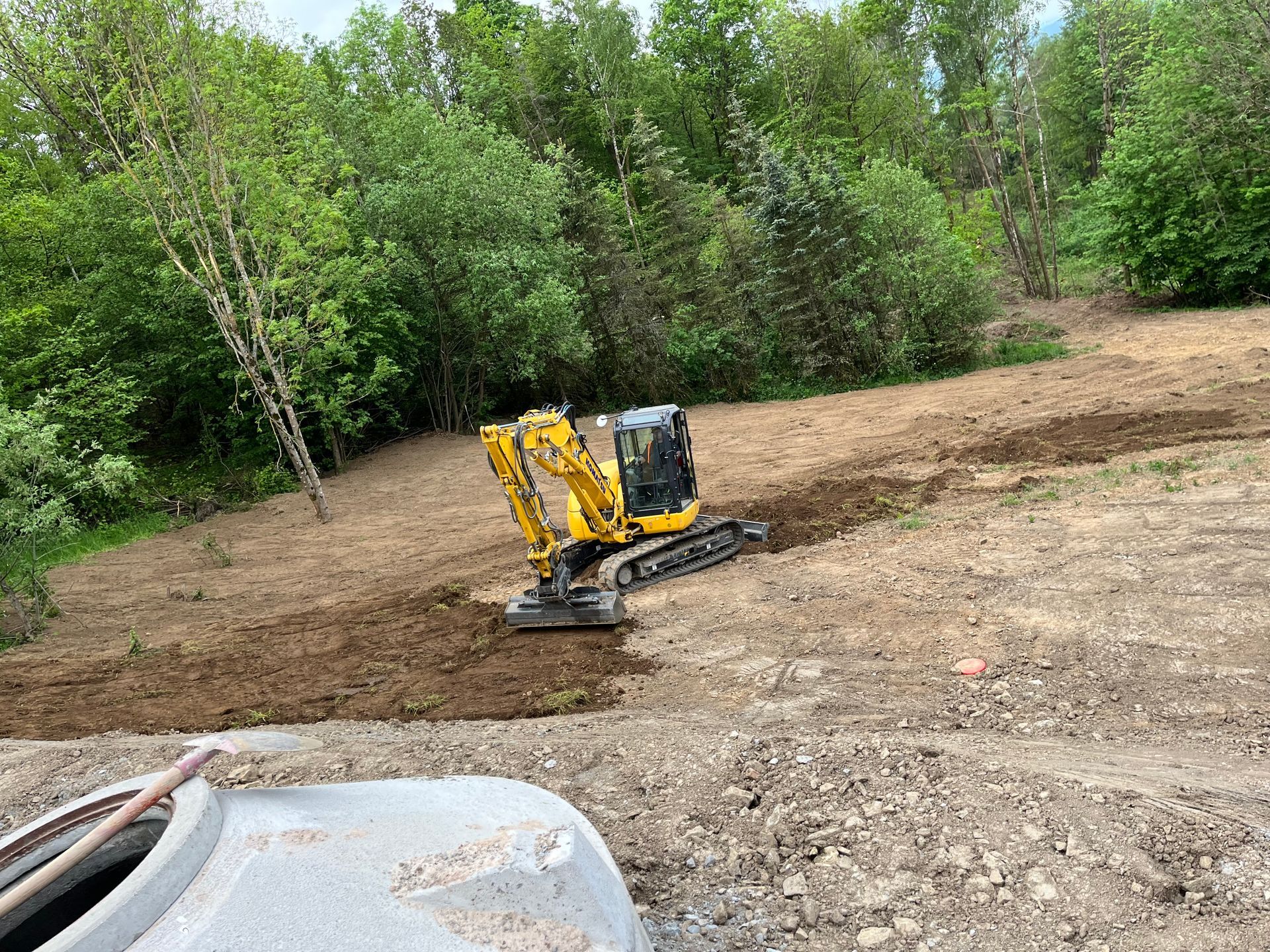 Bagger hebt Graben aus – Bauarbeiten auf einer Baustelle für Versorgungsleitungen oder Fundamente.