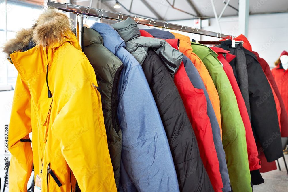 Una fila di giacche colorate appese a un attaccapanni