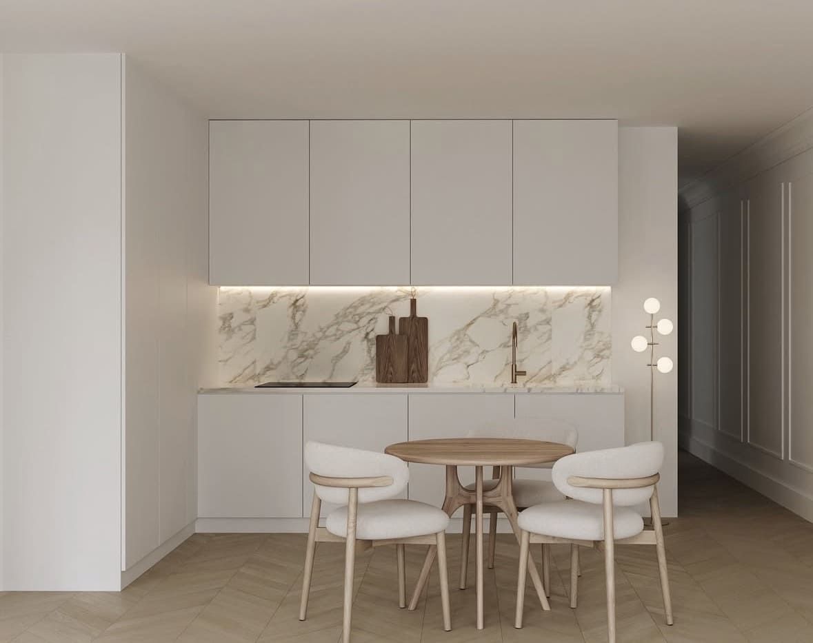 Reforma de habitación: mitad sin terminar con pared y escalera a la vista, otra mitad pintada de blanco, suelo de madera.