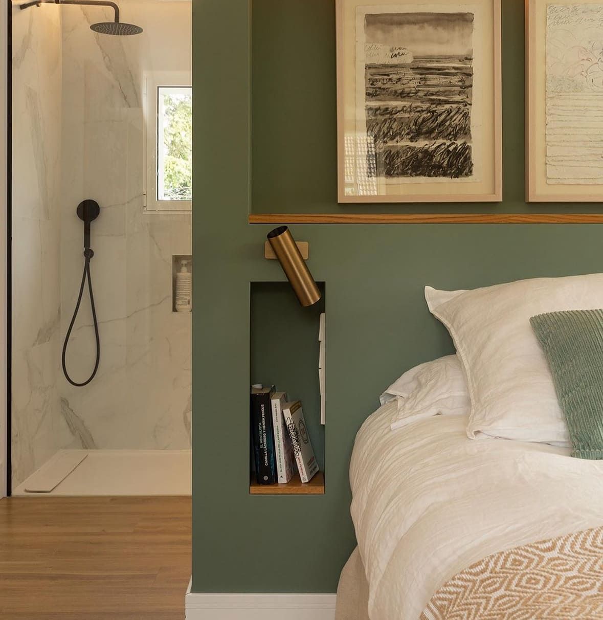 Dormitorio con pared verde oliva, estantería empotrada y cabina de ducha.