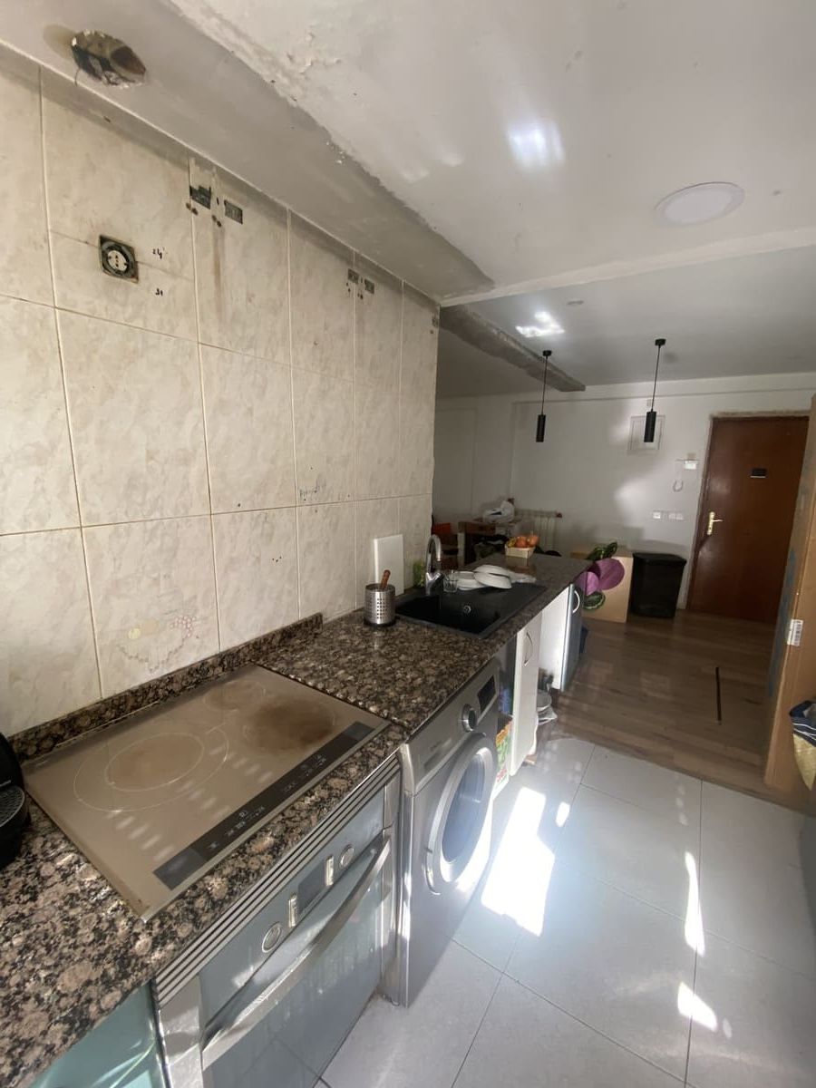 Cocina con gabinetes de madera, electrodomésticos blancos y salpicadero de azulejos. Texto 