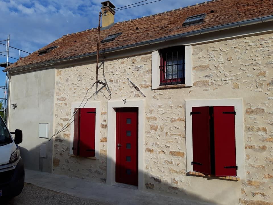 Une maison avec des fenêtres rouges.