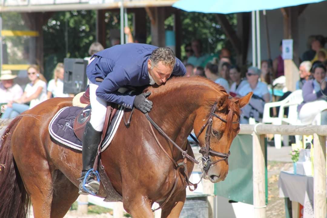 Cavalier en concours enlaçant son cheval