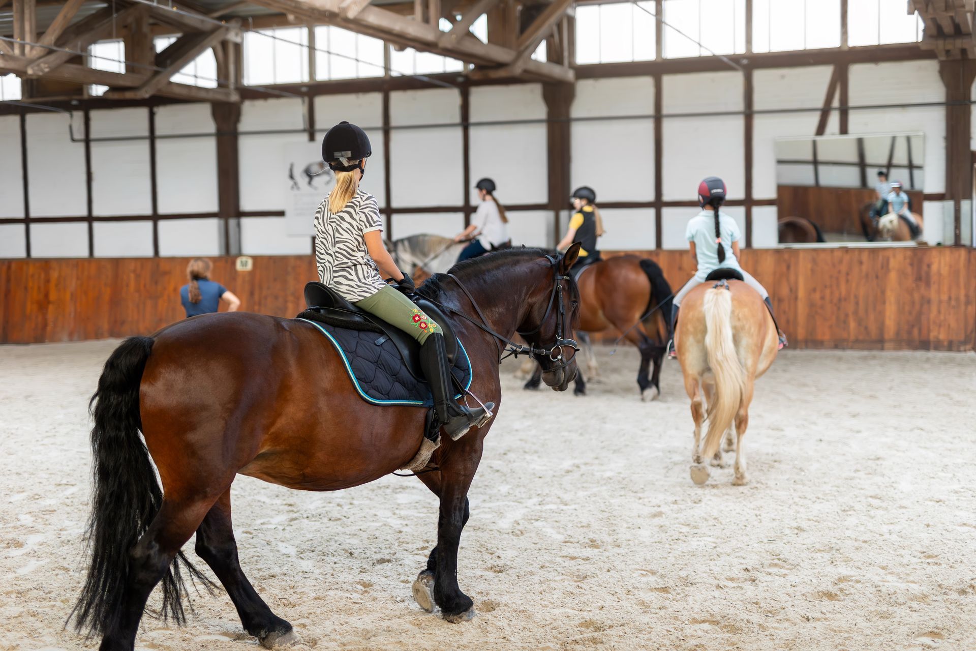 Enfant à dos de cheval tournant dans le manège couvert