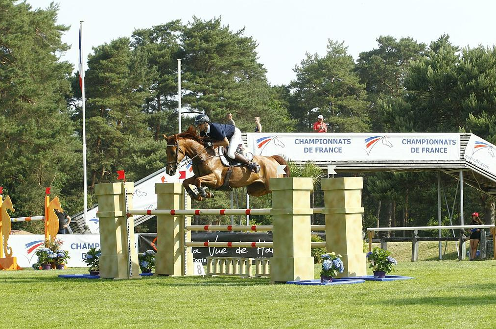 Cavalier sautant un obstacle durant le championnat de France