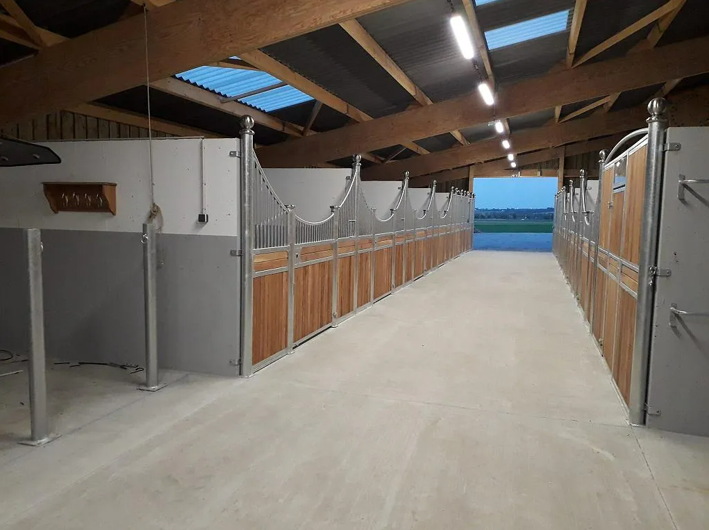 Couloir du haras avec des box pour les chevaux de chaque côté