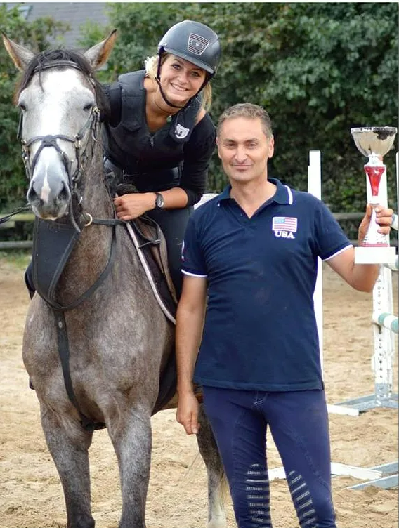 Cavalière sur son cheval et un homme à côté tenant une coupe