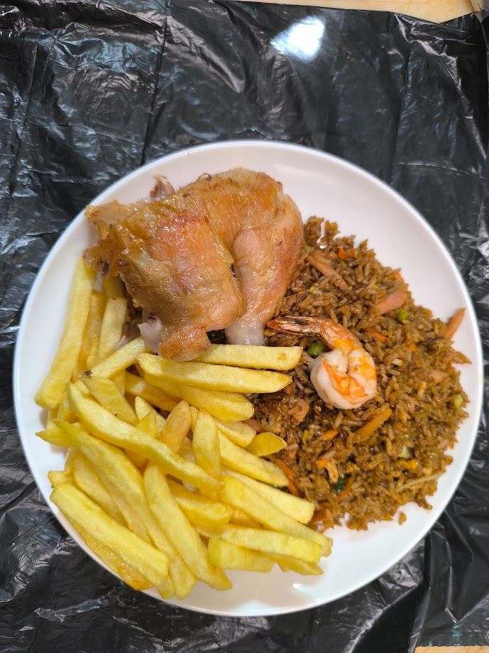 Plato con pollo frito, papas fritas y arroz frito con camarones.