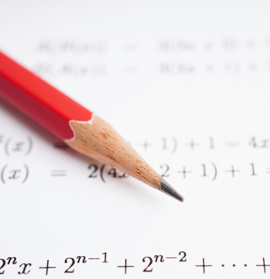 Un lápiz rojo está encima de un problema de matemáticas.