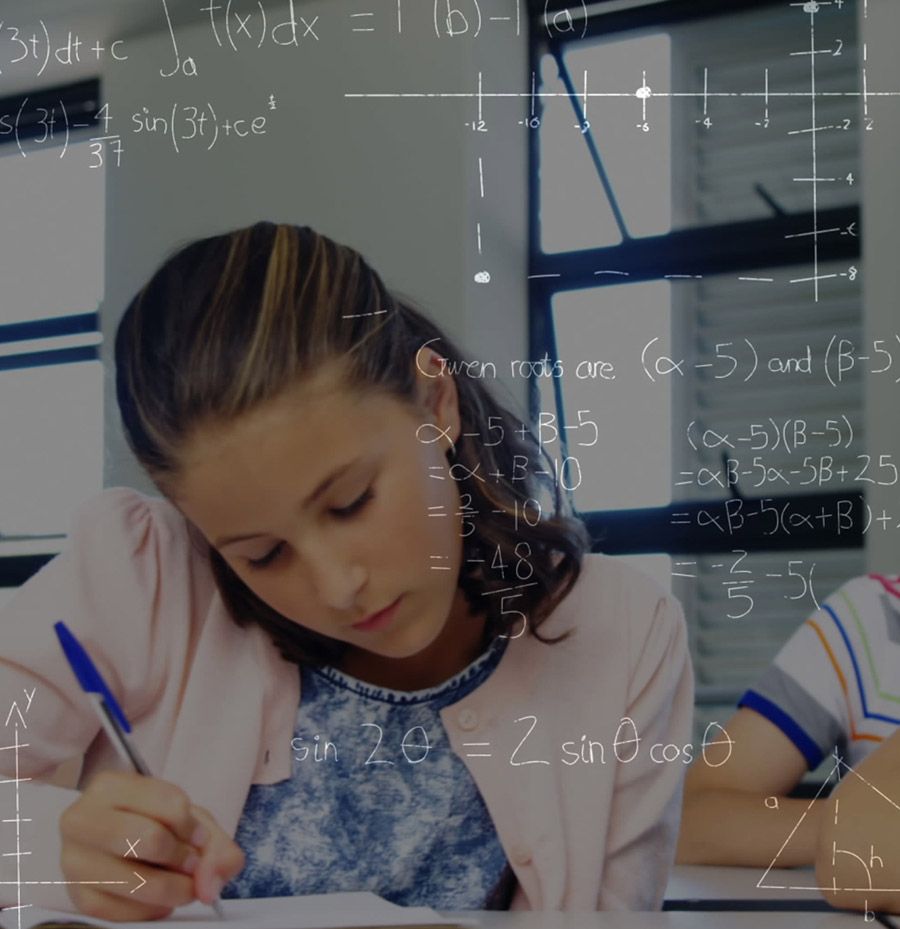 Una niña está escribiendo en un trozo de papel con ecuaciones matemáticas detrás de ella.