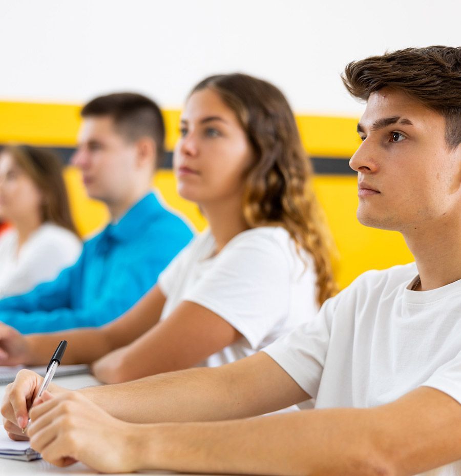 Un grupo de personas está sentada en una mesa en un aula.