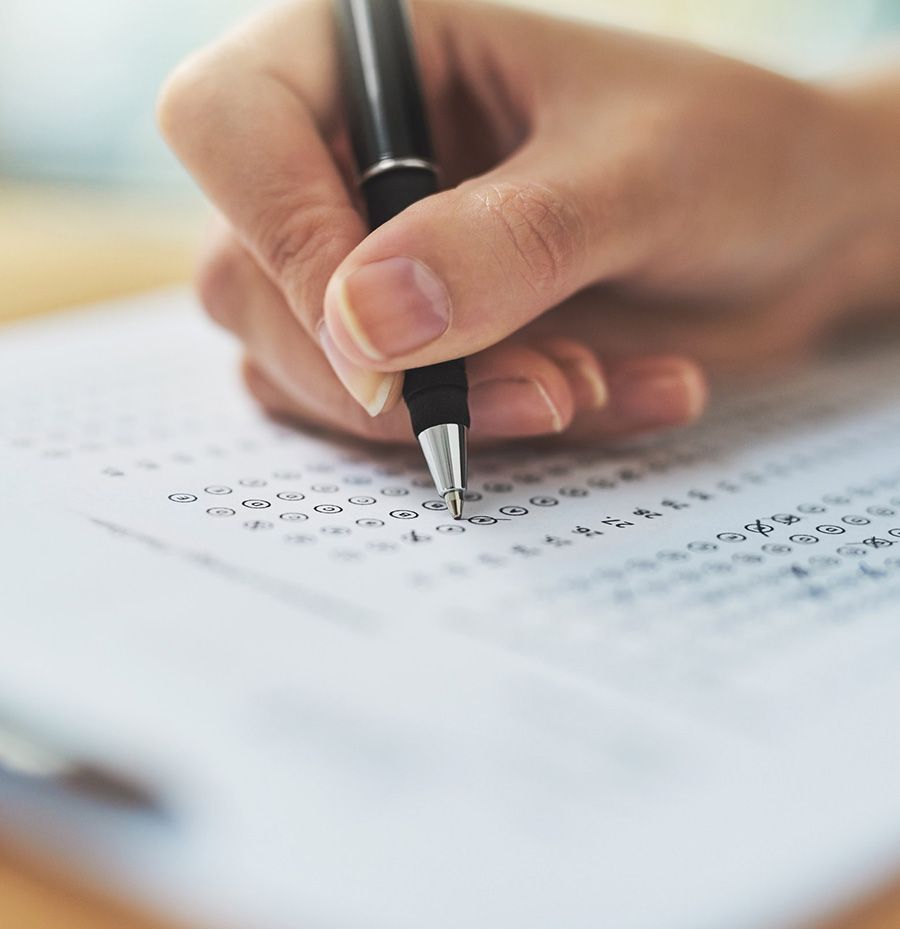 Una persona está escribiendo en un trozo de papel con un bolígrafo.