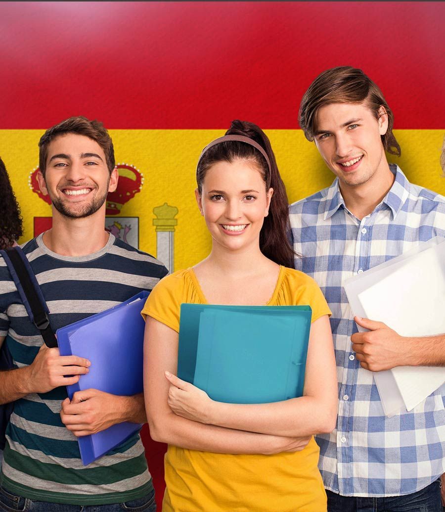 Un grupo de estudiantes de pie frente a una bandera española.