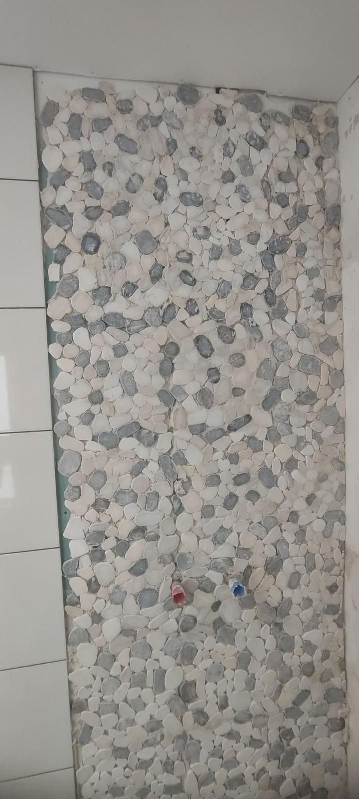 Panel de papel pintado con estampado floral en una pared, junto a armarios blancos.