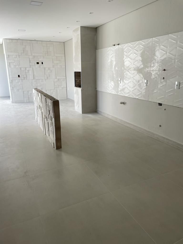 Interior moderno y vacío con grandes paredes de azulejos blancos y suelo de hormigón pulido.