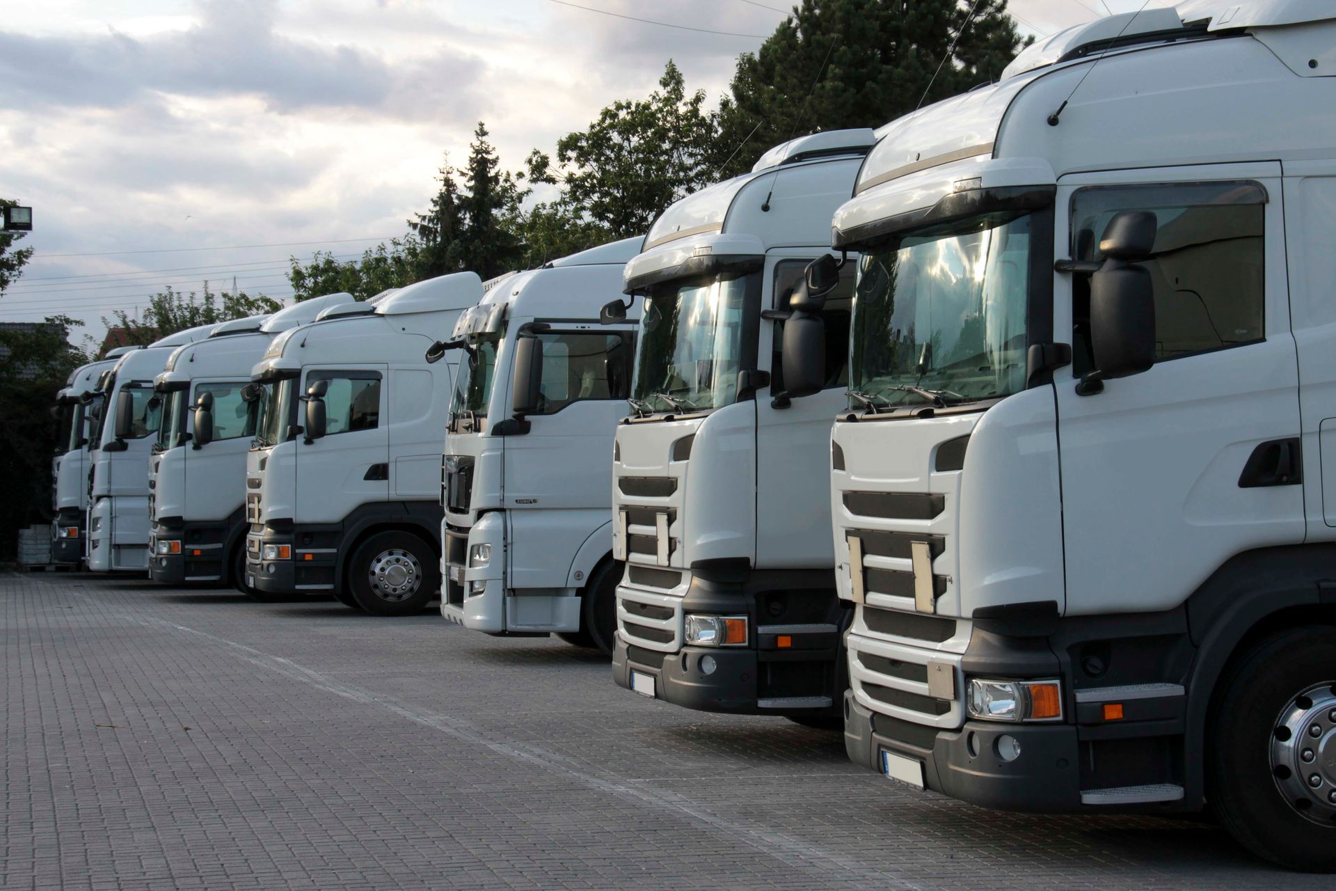 eine Reihe von weißen Lastwagen in einem Parkplatz