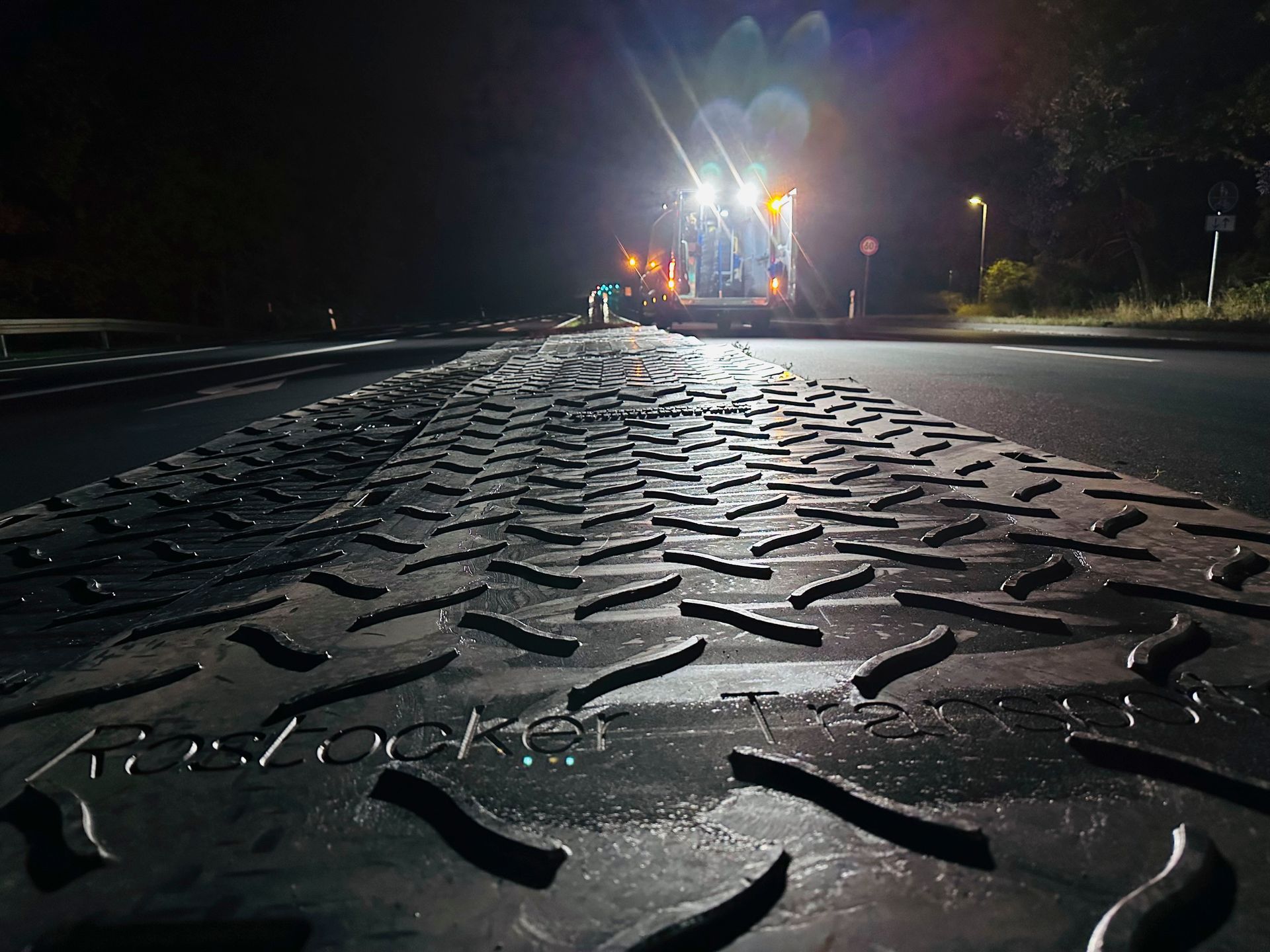 ein LKW fährt auf einer Straße in der Nacht
