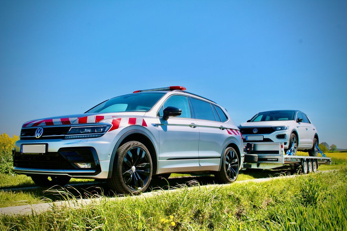 ein schwarzes Auto liegt auf einem Anhänger eines Abschleppwagens .