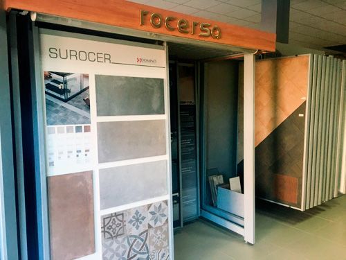 Una sala de exposición llena de muchos azulejos y un cartel que dice surocer.