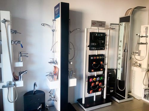 Un baño con muchas duchas y grifos en exhibición.