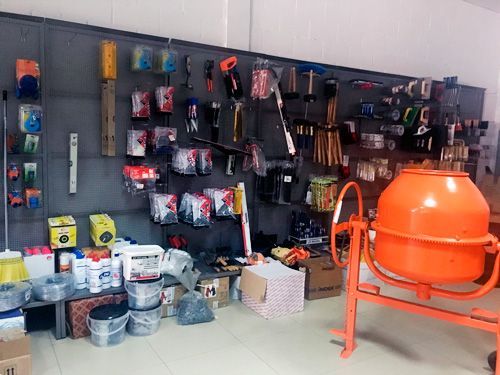 Una tienda llena de herramientas y una hormigonera.