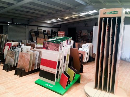 Una exhibición de azulejos en una tienda con un soporte verde que dice Excelsior.