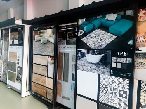 Una sala de exposición llena de azulejos y fotografías de una sala de estar y un baño.