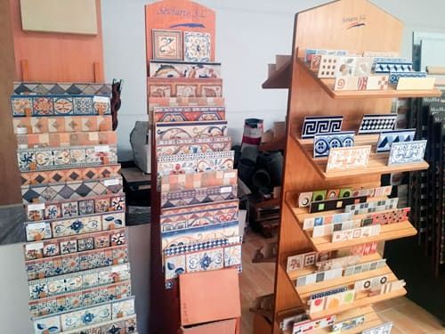 Una exhibición de azulejos en una tienda con un cartel que dice 'cerámica'.