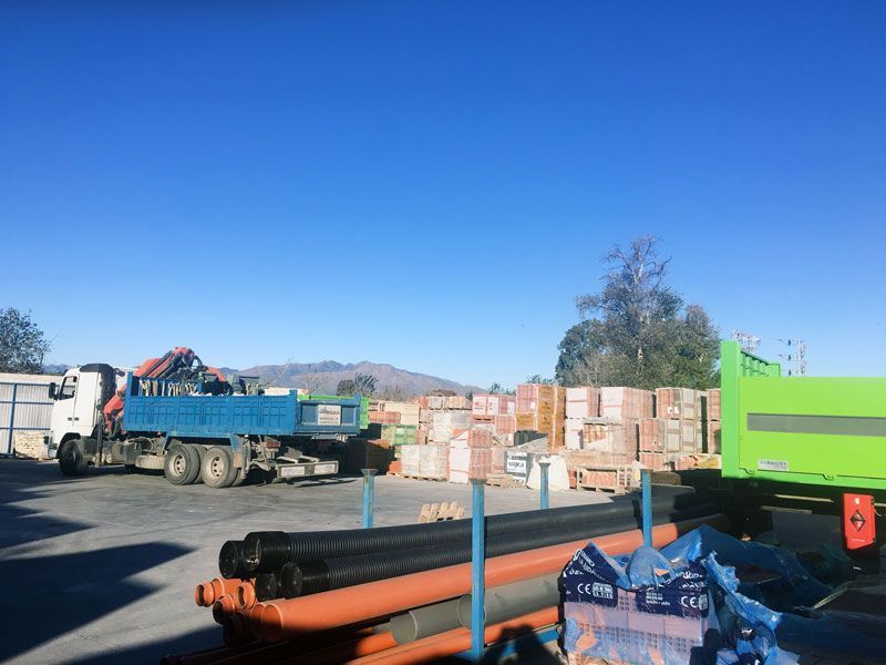 Un camión azul está estacionado en un estacionamiento al lado de un camión verde.